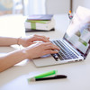 Image detail: The hands of a person sitting at a desk and working on a laptop can be seen.