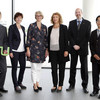 Gruppenfoto mit drei Männern und drei Frauen, die vor einer Fensterfront stehen.