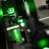 Close-up of a metallic machine that glows green.