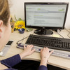 A blind student is learning at a computer using a special keyboard.